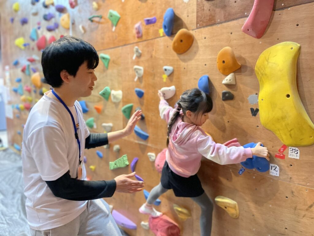 パンダBOXで子どもの登りをコーチが支える様子