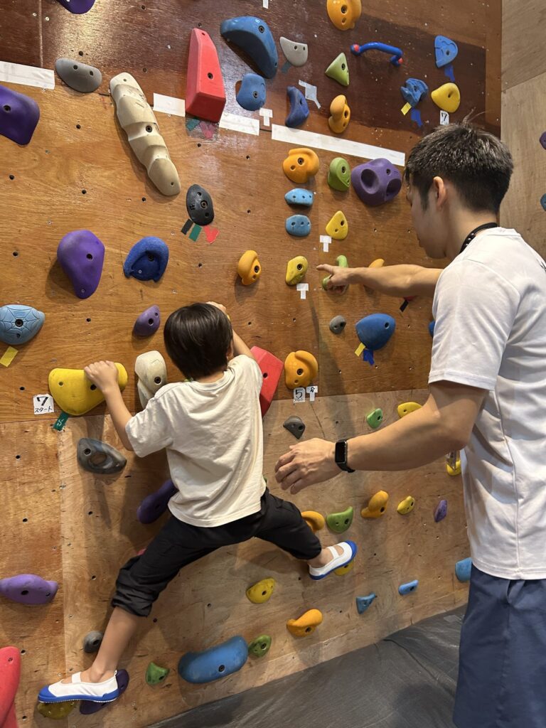 パンダBOXのスクールで登る子どもをコーチが見守る様子