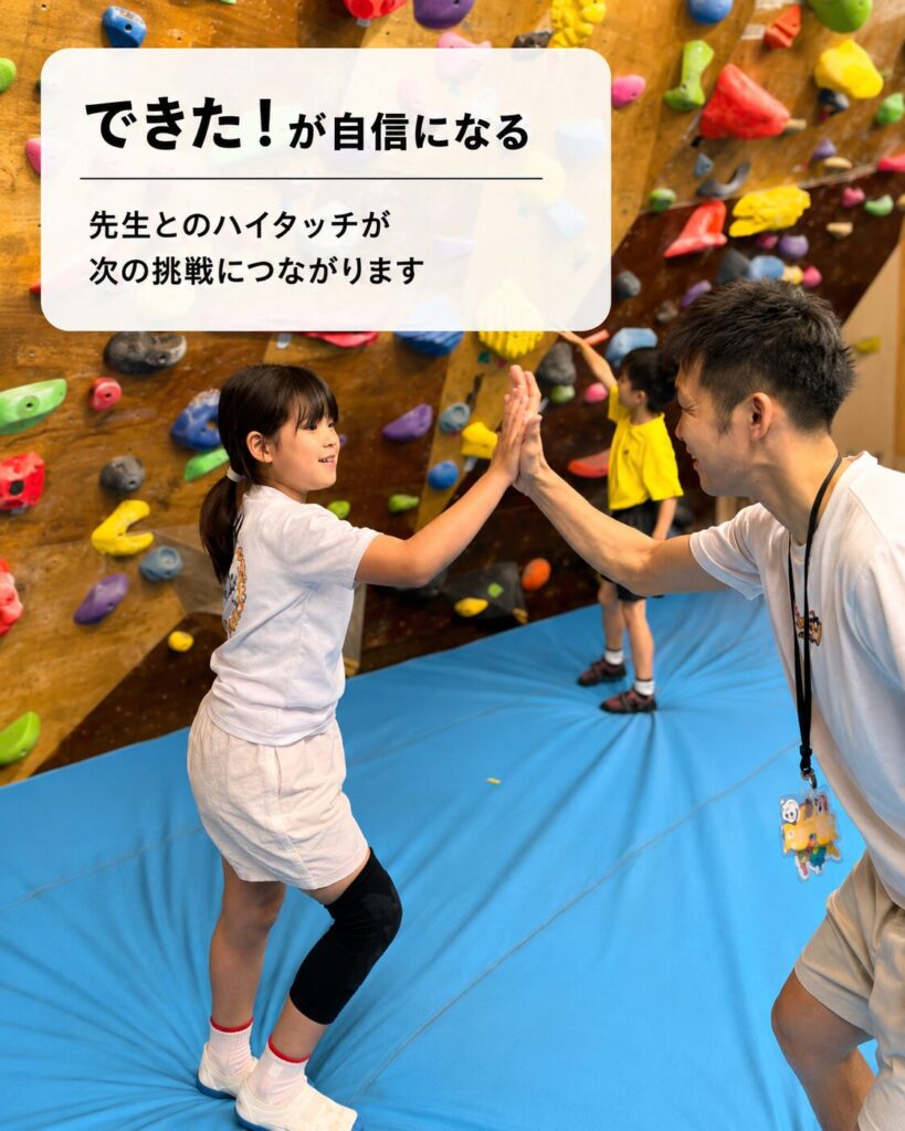 ボルダリングに挑戦するキッズスクールの子ども